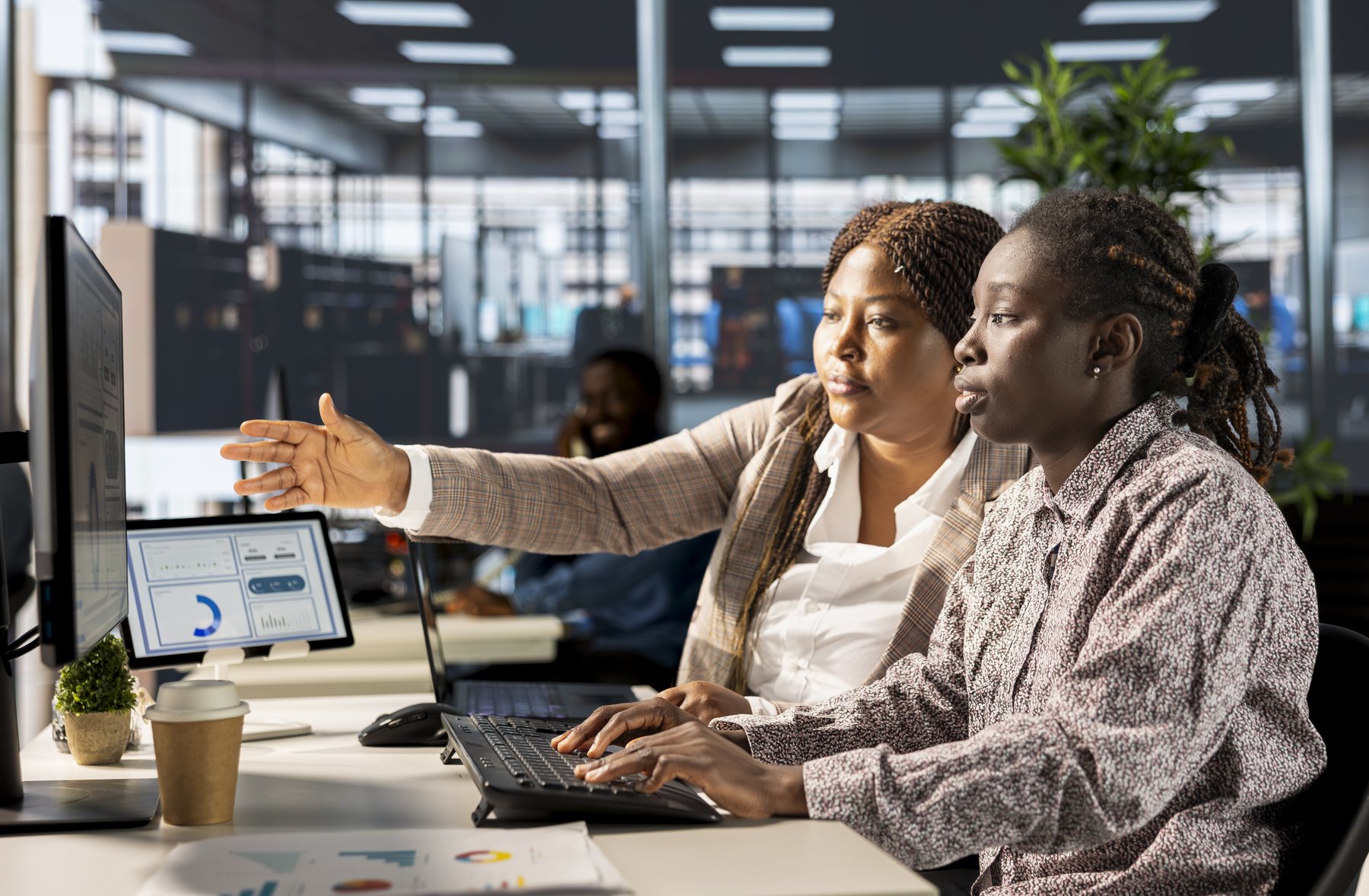 Facilitator guiding a colleague through information displayed on a computer